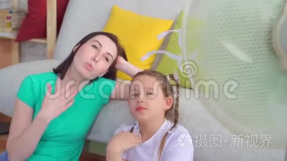 扇子旁边的肖像母女遭受着炎热的天气