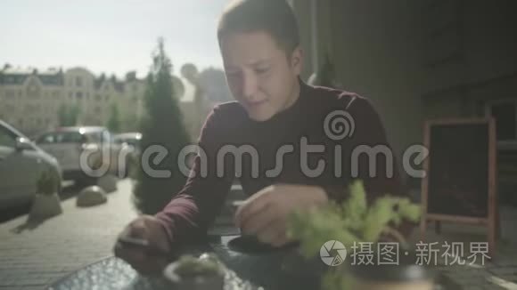 年轻人在夏天的咖啡馆里喝咖啡