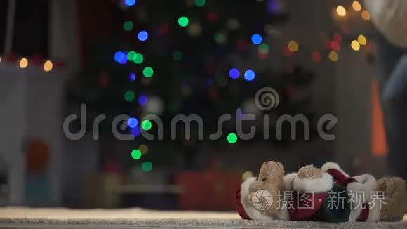 可爱的女孩穿着圣诞老人的服装，在玩耍和拥抱泰迪熊，圣诞树发光