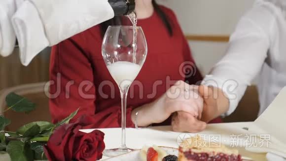 婚姻观念。 爱情和浪漫的关系。 服务员把香槟倒入玻璃杯中，让两个人慢动作。 特写镜头