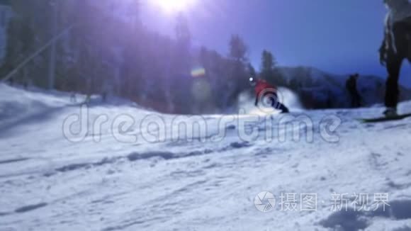 专业骑手在滑雪坡上滚动。 转身，雪飞进照相机..