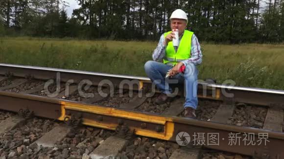 铁路工人坐在铁轨上喝咖啡视频