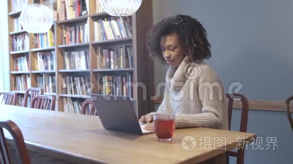 坐在咖啡店用手提电脑的临时女学生