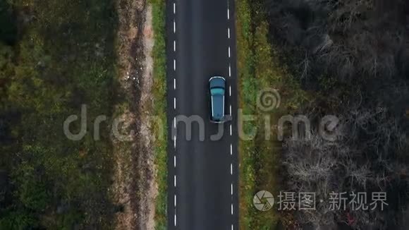 俯视无人机跟随黑色SUV汽车在多云秋林公路上行驶，冒险概念。