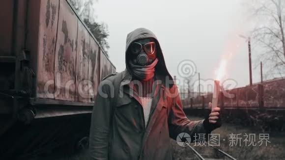 戴防毒面具的人穿过废弃的火车站拿着信号火