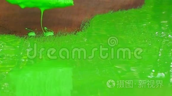 用丙烯酸绿色油漆画一个木制表面。