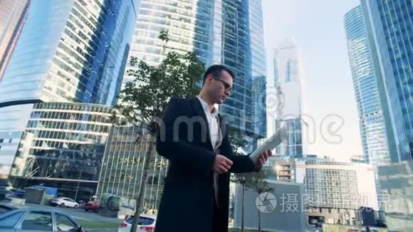 由摩天大楼组成的商业综合体，旁边站着一位年轻成功的男性商人