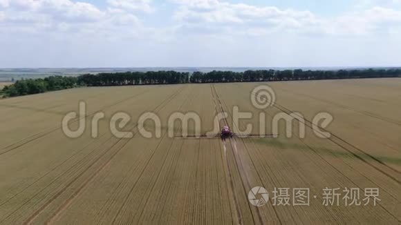 一架自行推进的喷雾器的长臂在给小麦浇水，空中镜头