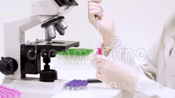 在实验室进行医学测试，科学家在实验室使用微型吸管。 把液体注入管子里。