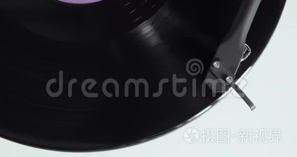 黑胶唱片在转盘上旋转，手臂和针，特写俯视图。
