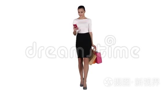 快乐的年轻女人，带着智能手机，在白色背景上拍摄她的购物袋。