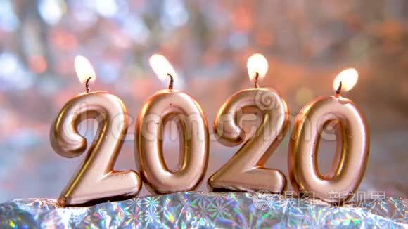 文字2020年金烛燃烧.. 模糊的闪光银色背景。 圣诞快乐，新年快乐。 选择性
