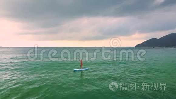 女人在海上划桨冲浪视频