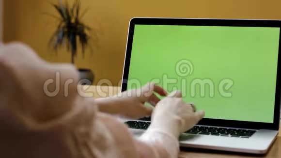 绿色笔记本电脑屏幕和女性手打字。 库存录像。 优雅的女士双手用绿色屏幕在笔记本电脑上打字视频的预览图