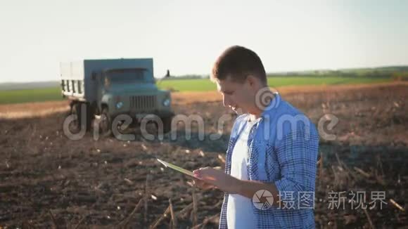 年轻农民的肖像，平板电脑站在田野里。 概念农户，食品，生物产品..