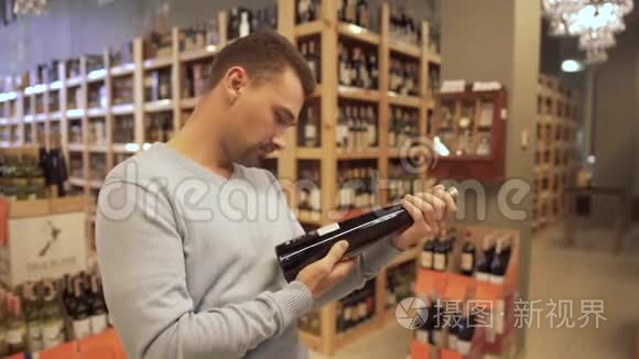 有魅力的家伙仔细检查了葡萄酒店里酒瓶标签上的成分。 酒瓶是