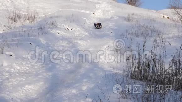 快乐的女孩在雪中滑下山。 冬天在圣诞公园玩的女孩。 慢动作