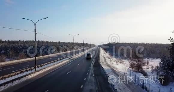 冬季道路上有交通车和卡车的高速公路的鸟瞰图。