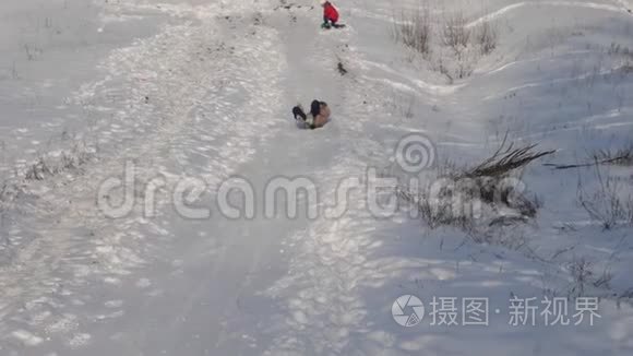 冬天，快乐的女孩从雪山上滚过白雪，微笑着。 慢动作。