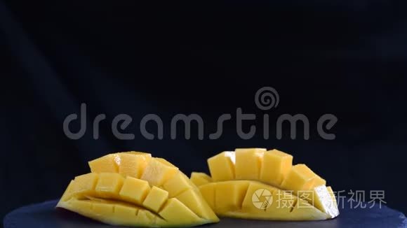 有机热带水果,在黑色盘子上关闭幻灯片芒果.短视频