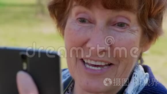 通过移动视频应用程序特写老年女性谈话，微笑