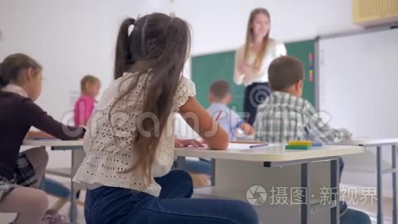 小学课堂课上微笑女生在课桌上的画像