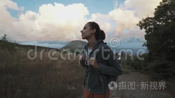 女子徒步山看着美丽多彩惊艳的晚霞天空..