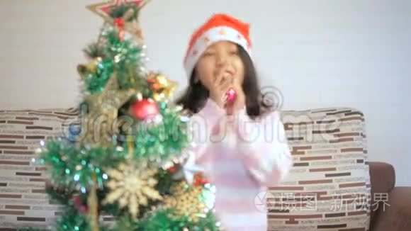 亚洲小女孩装饰一棵圣诞树，快乐地跳舞