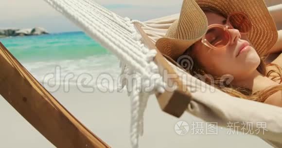 4k海滩吊床上放松的白人妇女侧视图