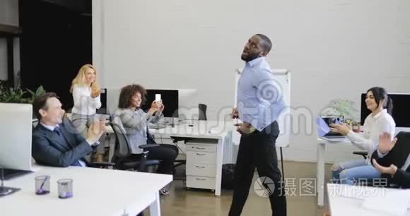 非裔美国商人在现代同事间跳舞，欢呼商务人士小组休息