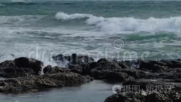 海上的风暴，海岸上的波浪破碎，海水的飞溅和岩石下的水的泡沫。 保加利亚黑海
