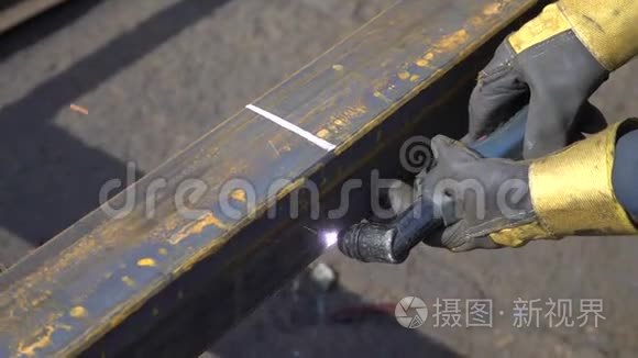 一个带手套的工作金属仓库用焊机切割金属横梁