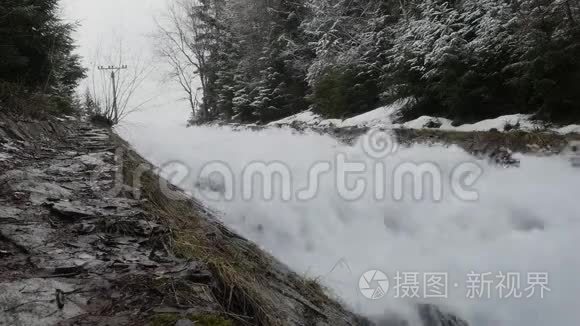 快速流动的瀑布在河流上形成巨大的泡沫，位于风景如画的春天，早春的自然之地