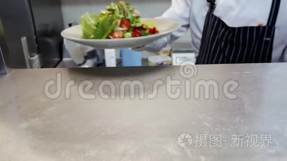 厨师在餐厅的厨房里给成品沙拉视频