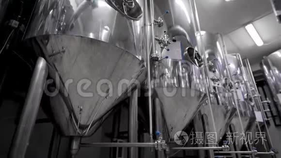 照相机正沿着闪亮的现代啤酒罐在啤酒厂酿造啤酒