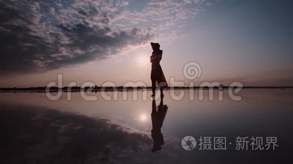 一个女人在夕阳背景下挥舞着裙子的剪影