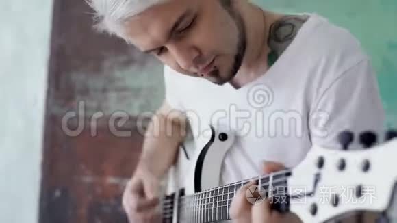 金发男用吉他工作视频