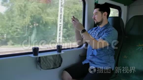 高加索人坐火车旅行。 在移动智能手机上拍摄大自然的照片。 慢动作