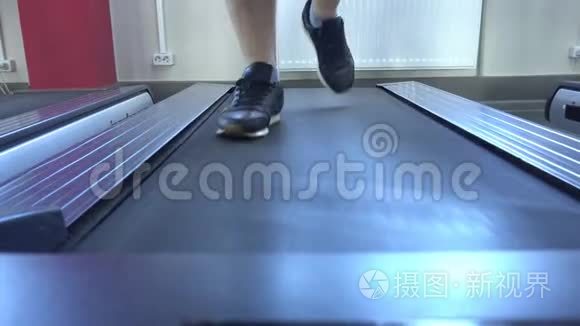 男人`在健身房的跑步机上跑步，减肥，有氧运动，特写，人