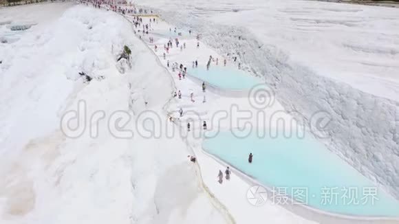 白色石灰石梯田上成群的游客。 帕穆卡莱，土耳其。 空中镜头