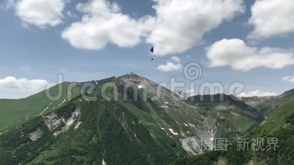 白种人绿山中的滑翔伞美景视频