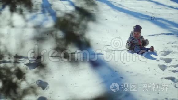 4K家庭冬季运动会。 这孩子正坐在公园的雪地上