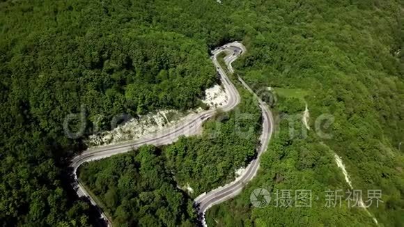 用汽车和卡车在山间蜿蜒曲折的道路上鸟瞰