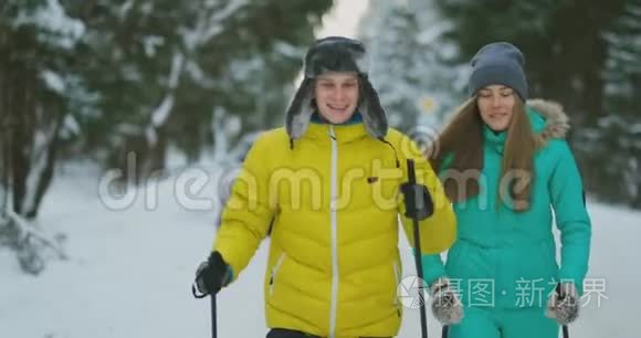 一对已婚夫妇正在森林里滑雪，练习健康的生活方式。 慢动作