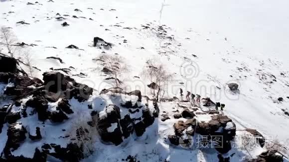 空中四翼飞机将这座山移走，覆盖着雪，飞过它。 对面是一群游客