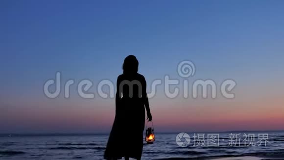孤独的女性穿着煤油灯看着夕阳的夜空