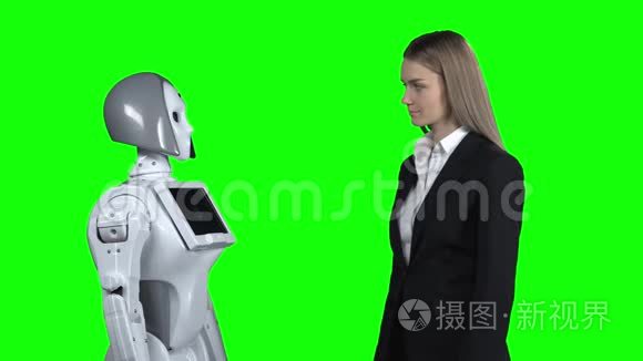 女孩欢迎机器人牵着他的手打招呼。 绿色屏幕
