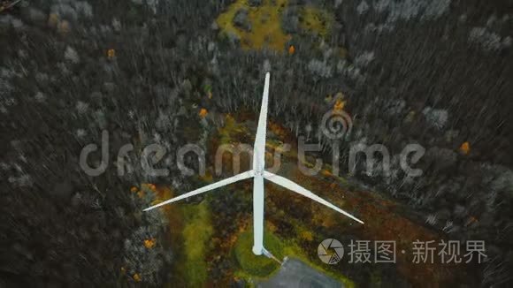 俯视无人机飞越工作风车在冬季森林，未来替代可再生生态友好能源概念。