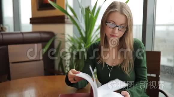 女人坐在咖啡馆里翻书