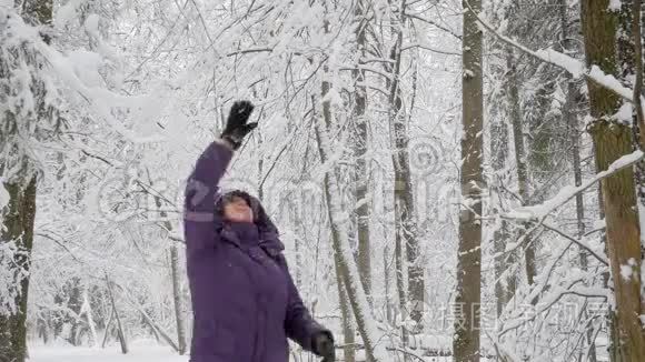 老妇人从树枝上摇下了雪，微笑着